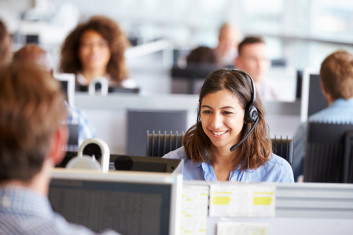 Colleague chatting on a headset in front of a computer