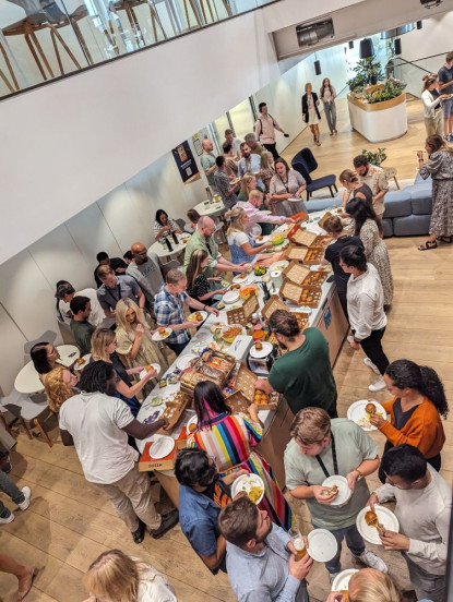 A large amount of people gathered around a buffet